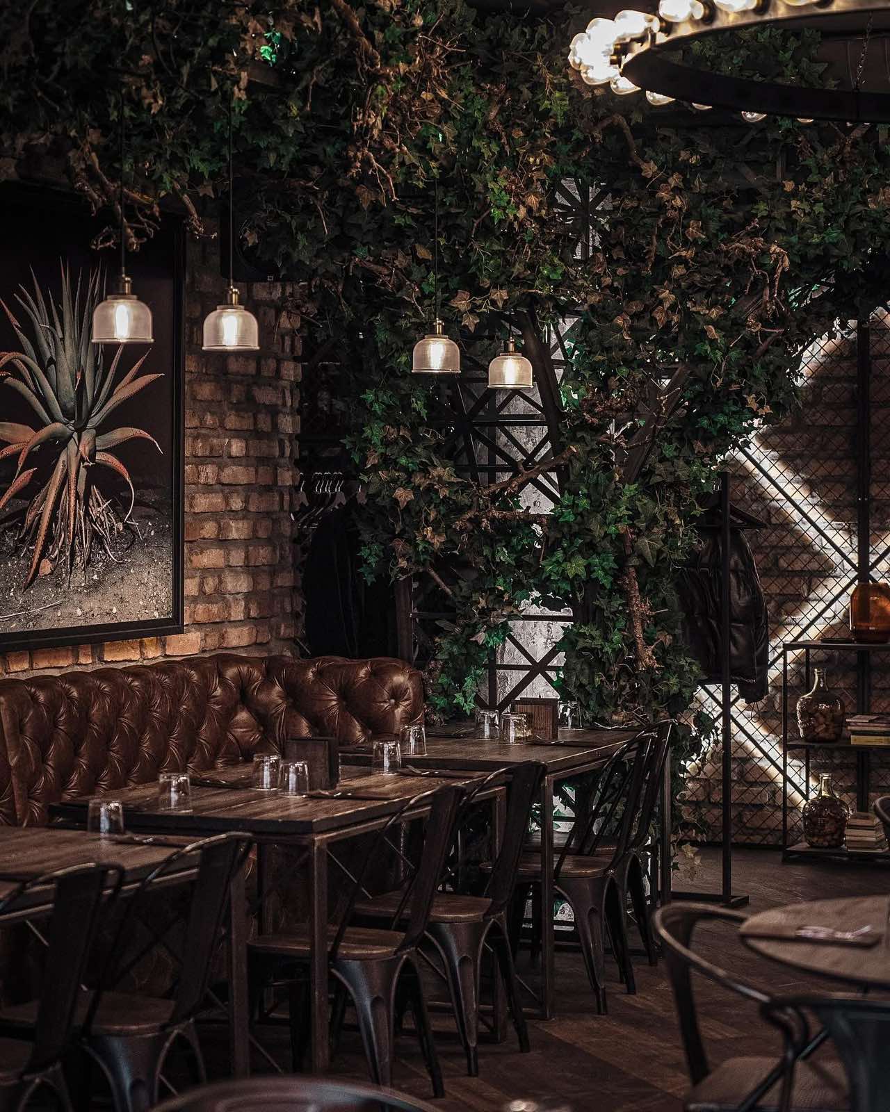 Odiniai suolai, sendintos plytos ir žaluma Grill Room interjere